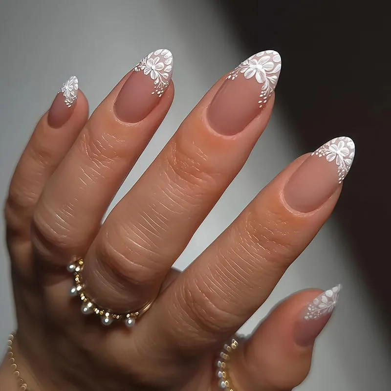 Medium-long almond nails with matte nude-pink bases and white lace floral French tips