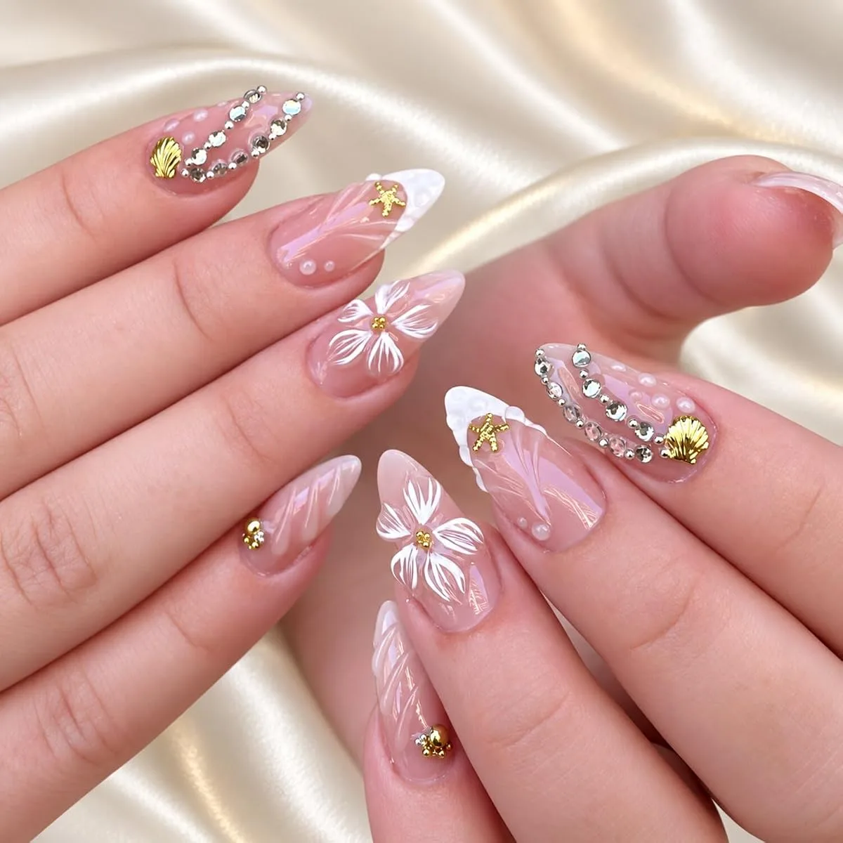 Long stiletto press on nails with gold shells, starfish and white flowers on sheer pink