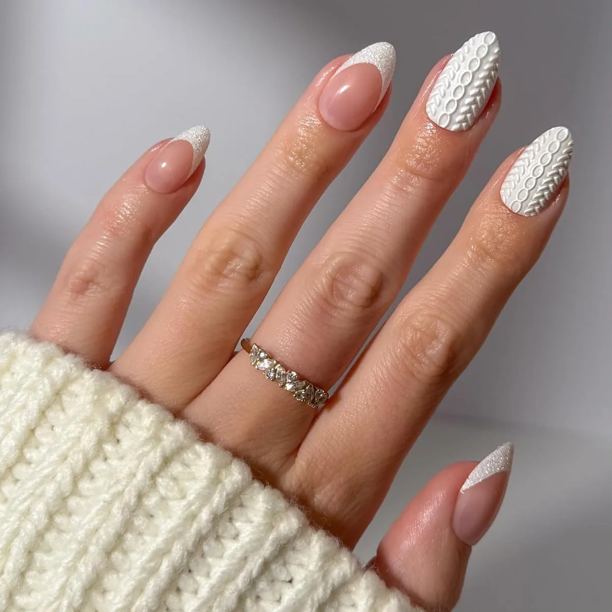 Acrylic false nails in nude pink with white glitter French tips and knit texture nails