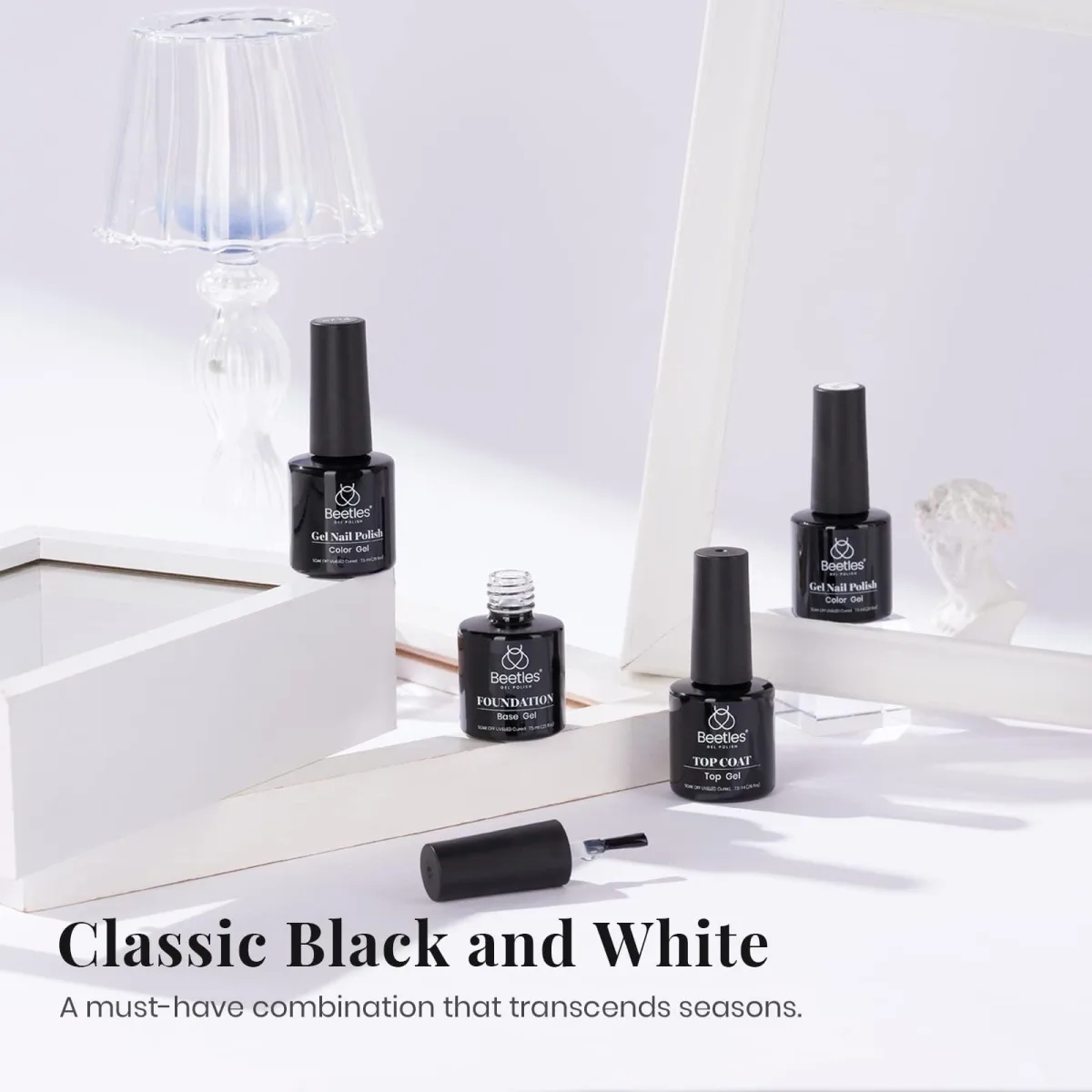 Four Beetles bottles styled on white blocks with Classic Black and White text for monochrome manicures