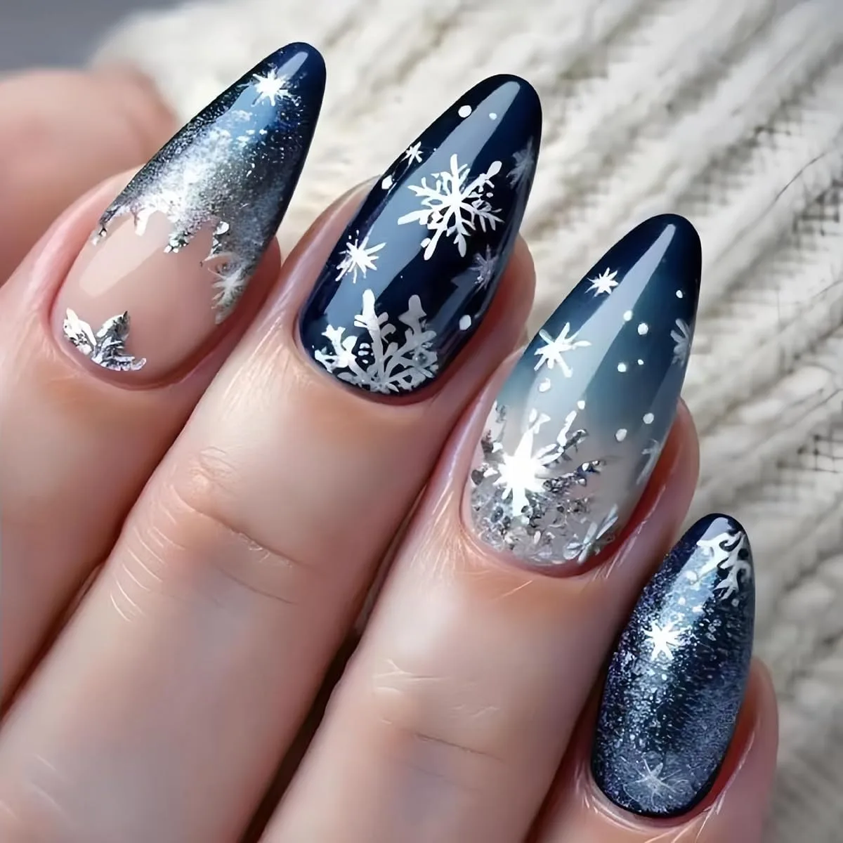 Deep navy acrylic false nails with white snowflakes and silver glitter on long stilettos
