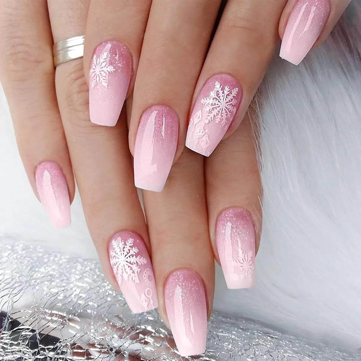 Pink gradient holiday nails with white snowflakes and glitter on long coffin nails