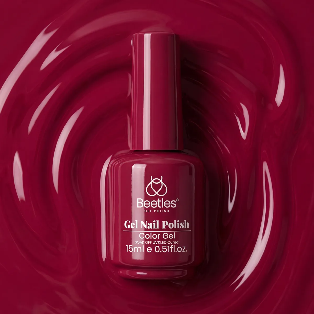 Beetles colour gel bottle in deep burgundy red standing in a swirl of red gel