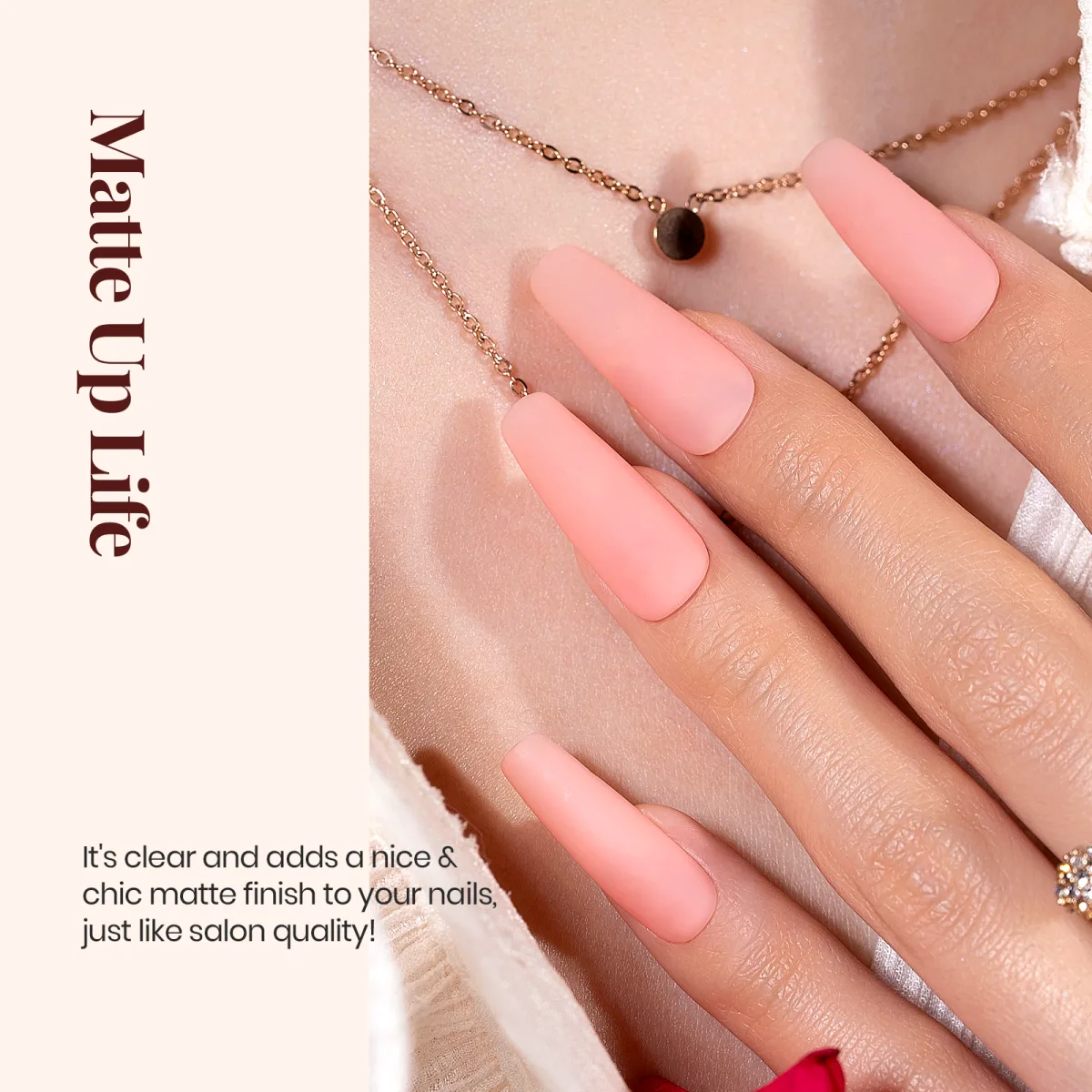 Hand with long coffin matte pink nails against a gold necklace