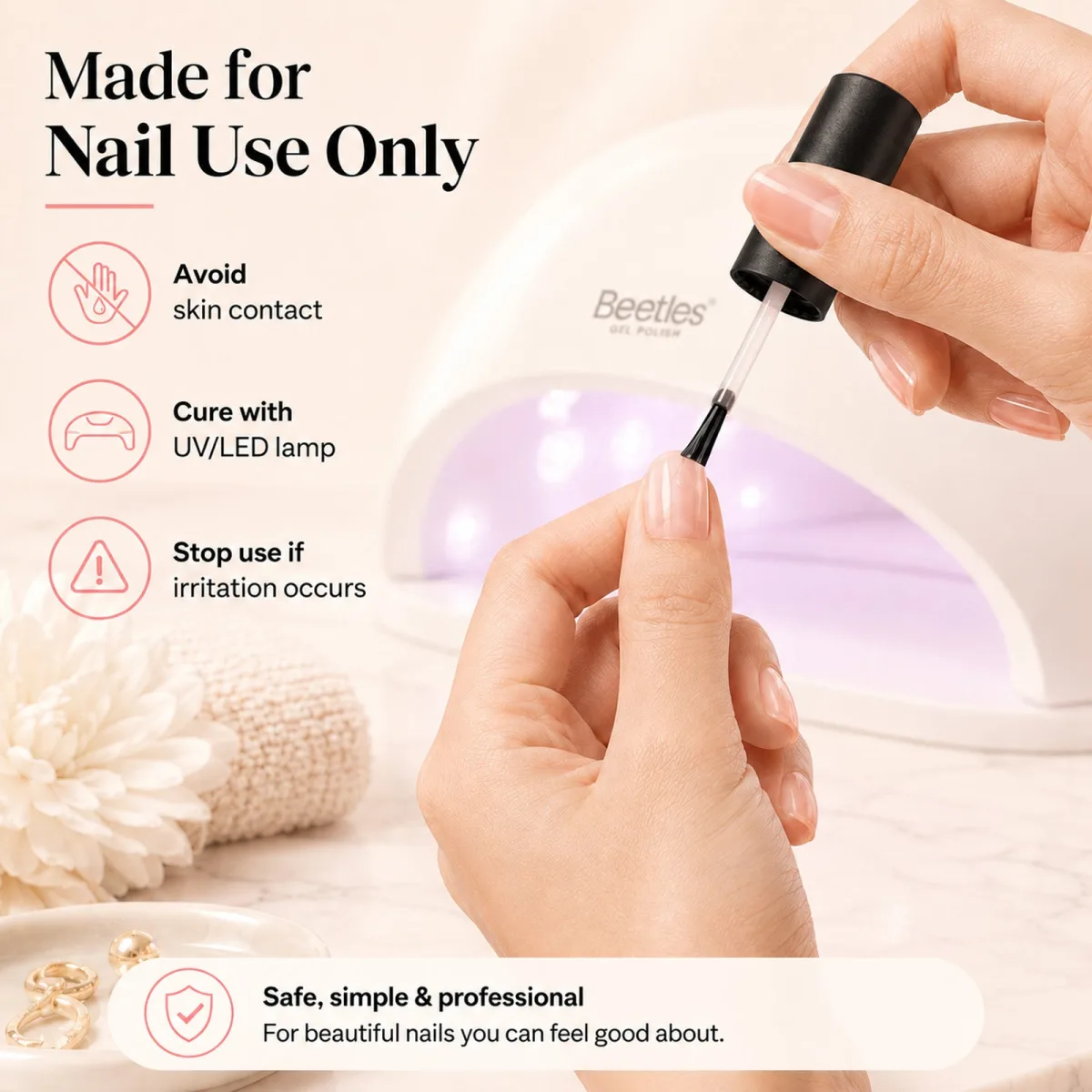 Hand applying clear gel polish with a Beetles UV LED lamp glowing in the background