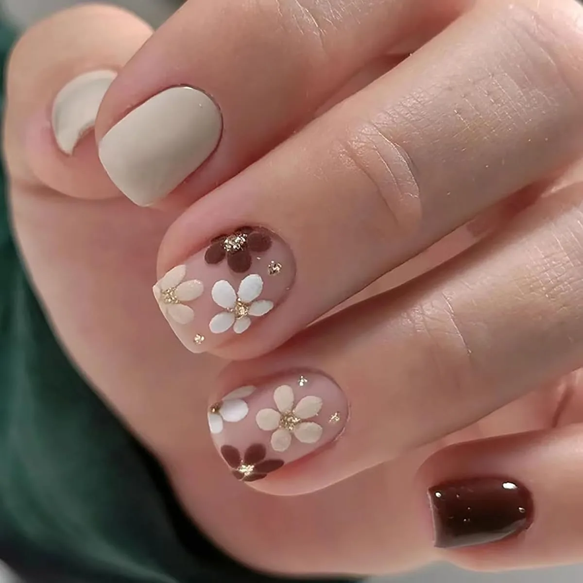 Hand with matte cream sheer pink brown floral nails and glossy chocolate brown solid