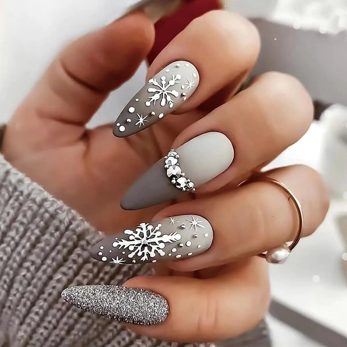 Matte grey acrylic false nails with white snowflakes and a silver glitter accent nail
