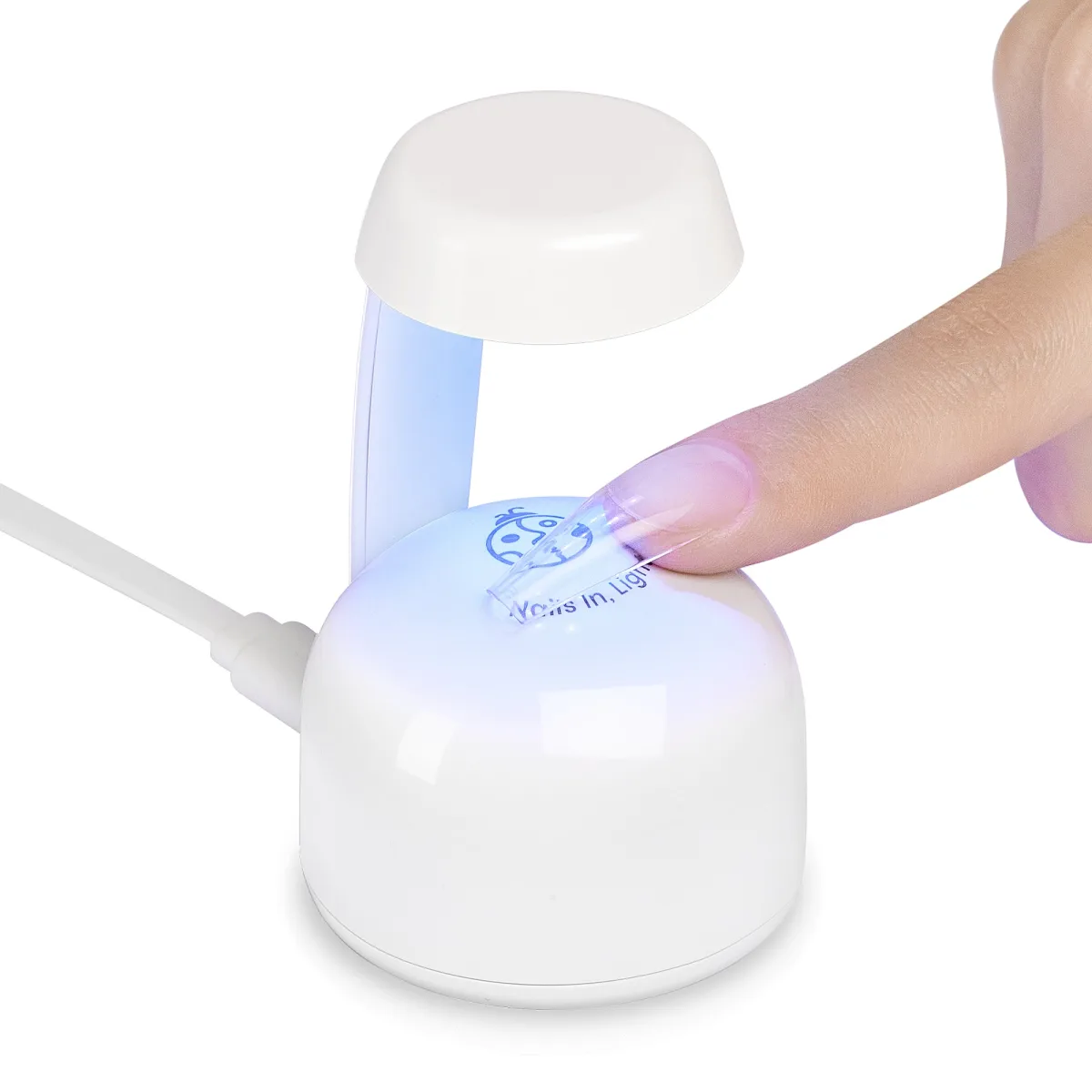 White mini UV LED nail lamp curing a clear coffin nail tip on a fingertip