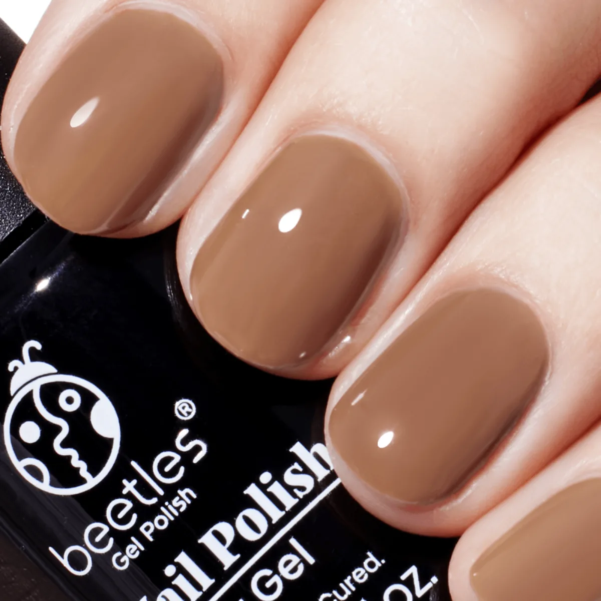 Short oval glossy caramel brown nails next to a Beetles gel polish bottle