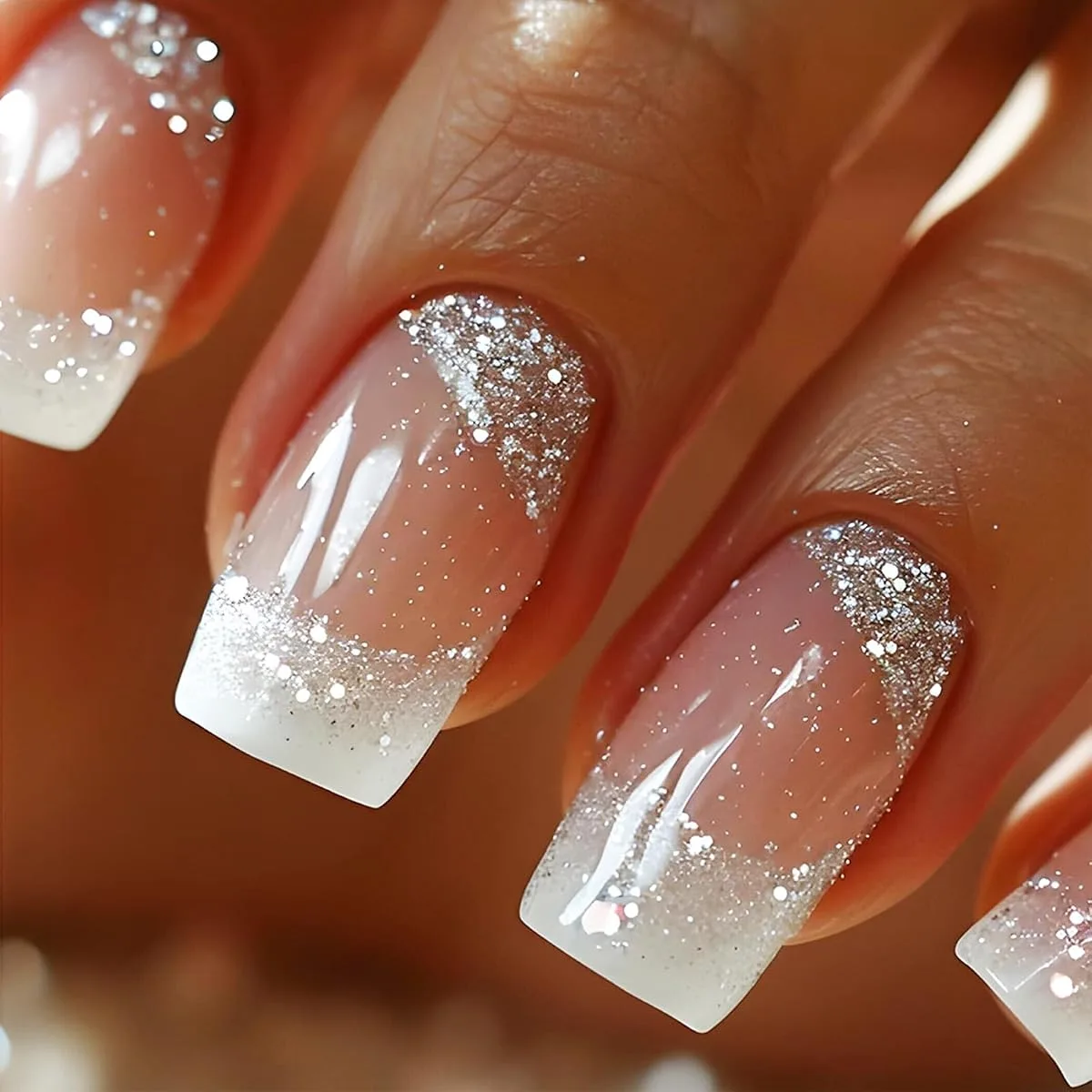 Medium square nails in sheer pink with white glitter French tips and silver glitter at the cuticle